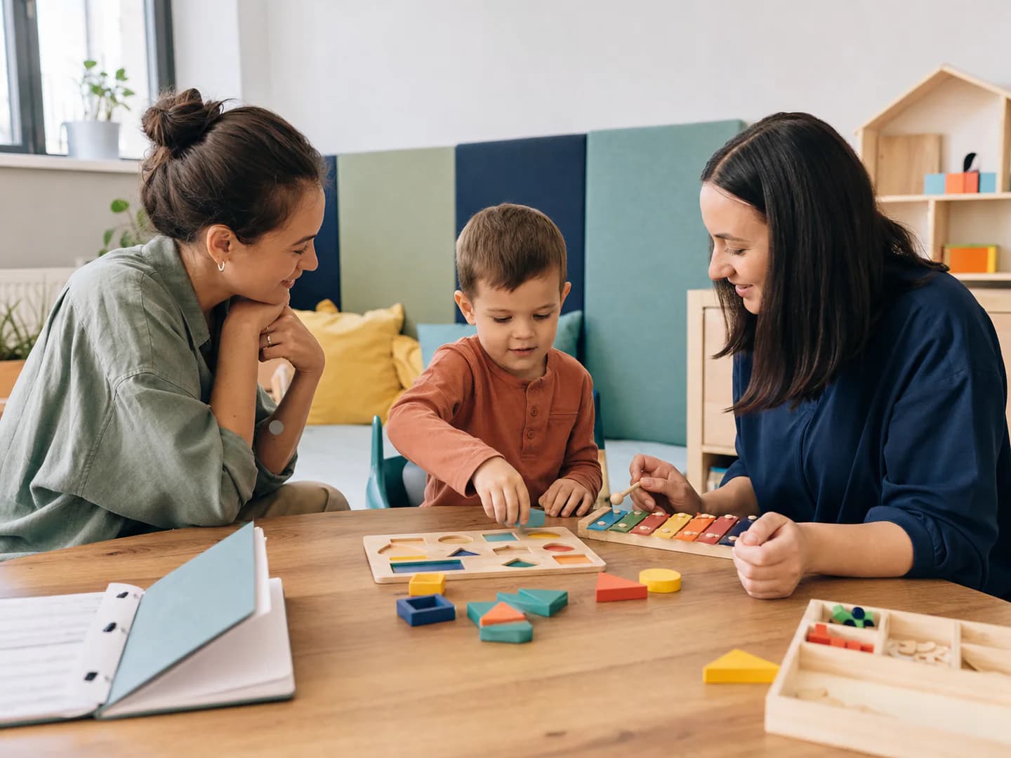 A child takes part in an early-support activity with two specialists