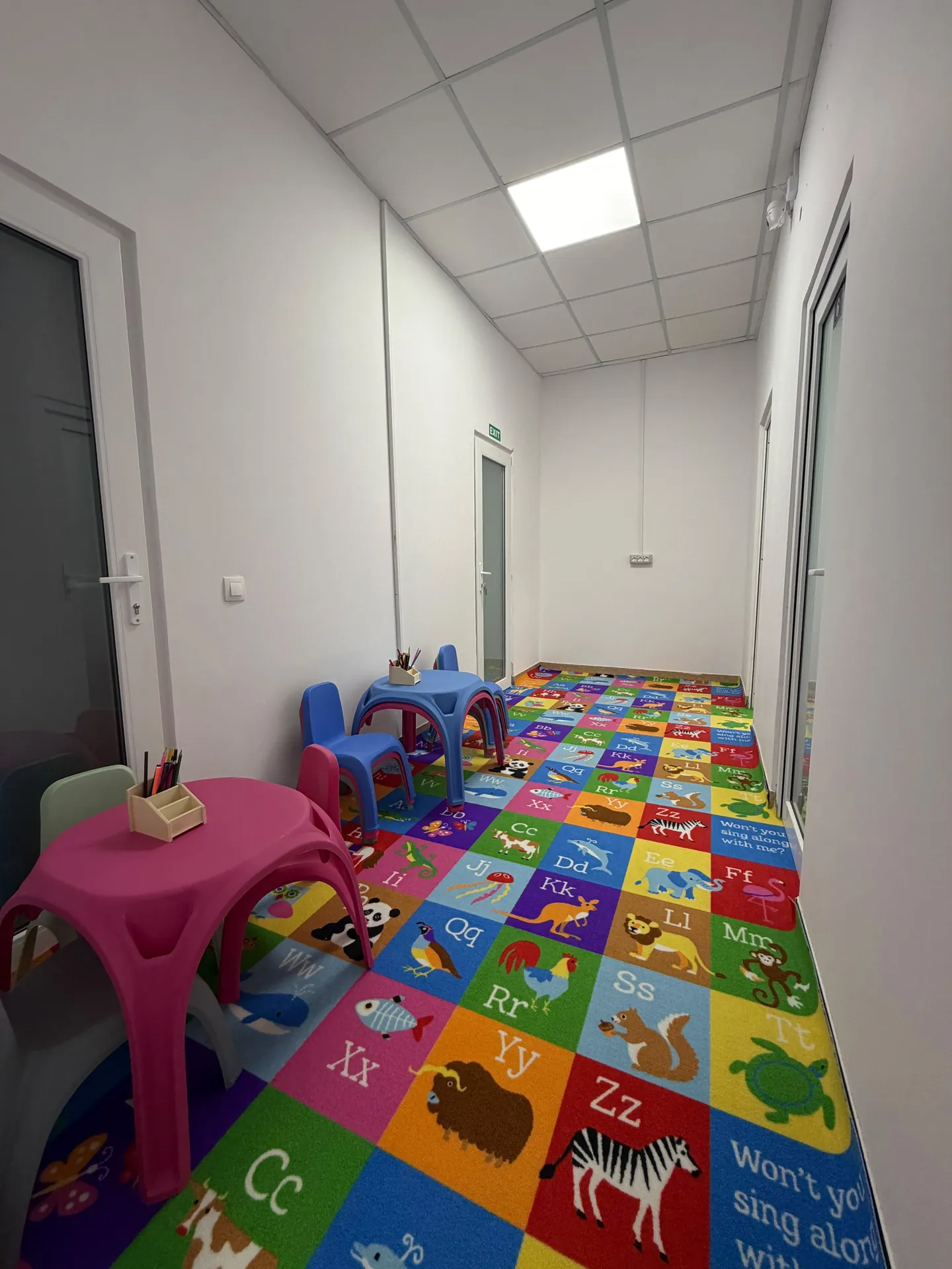 The center’s corridor, with a colorful rug, small tables and children’s chairs.